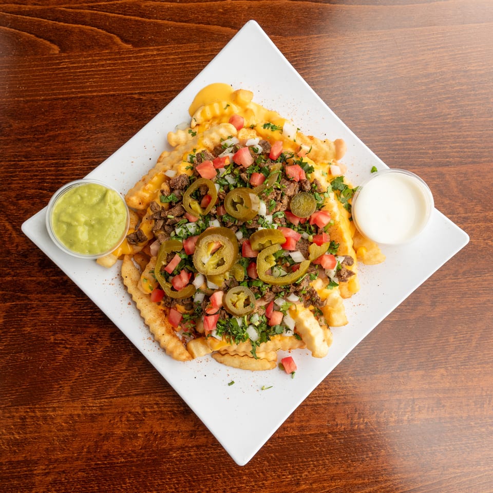 Loaded crinkle-cut fries with cheese, ground beef, tomatoes, onions, cilantro, and jalapeños.